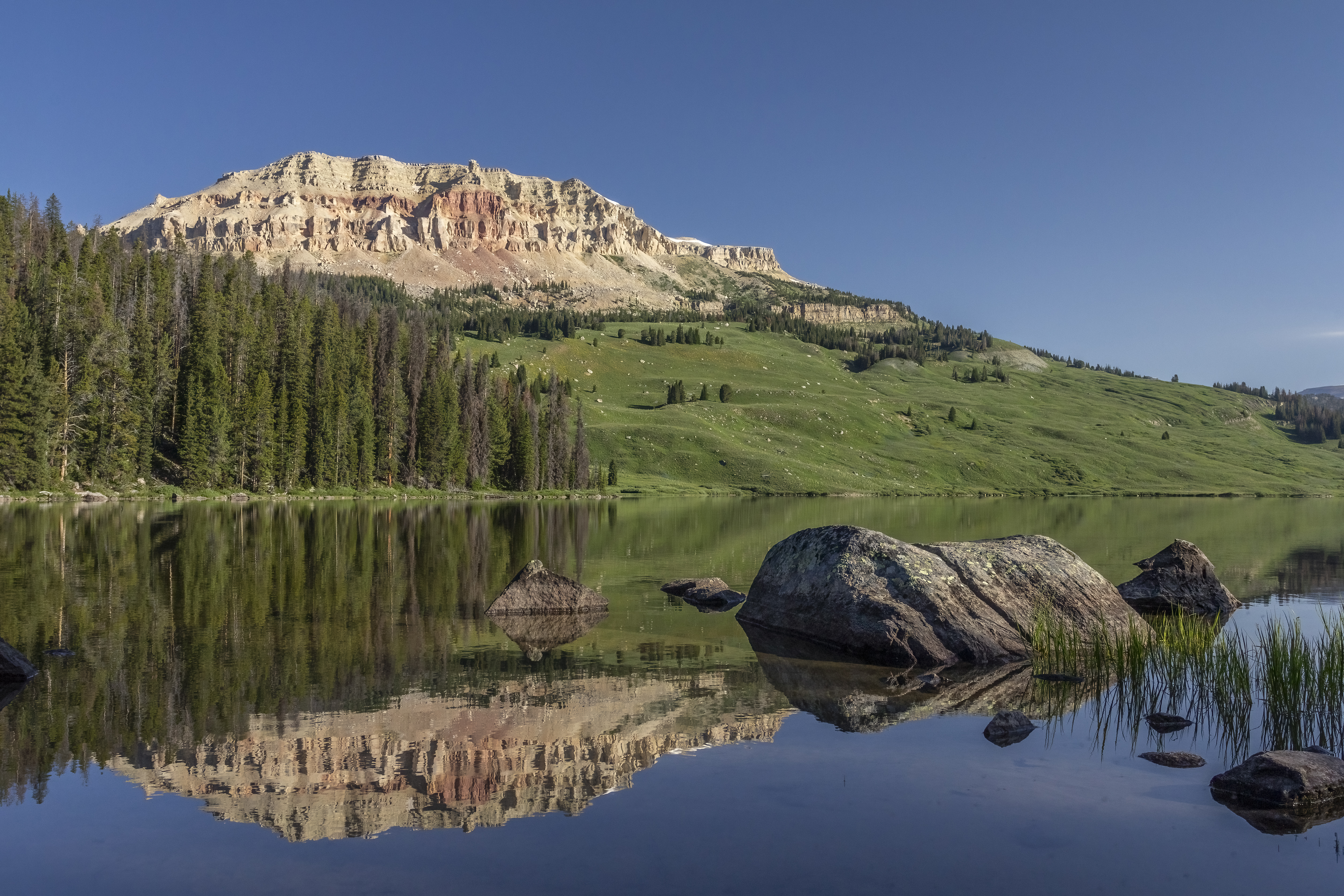 a calm reflective river showing the mountains in the background in the foreground
